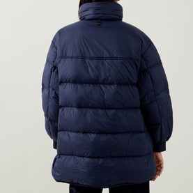 Model wearing HIGH dark blue quilted puffer coat, rear view, high collar, relaxed longline silhouette