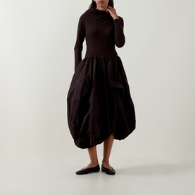 Model wearing HIGH brown dress with fitted turtleneck top and voluminous balloon skirt, styled with black flat shoes