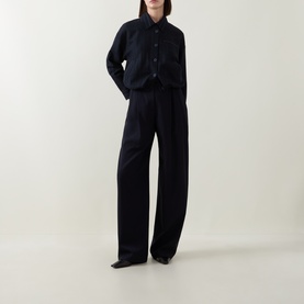 Model wearing HIGH navy cropped jacket with button front, styled with wide-leg navy trousers and black shoes.