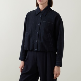 Model wearing HIGH navy cropped jacket with contrast stitching, button front and chest pocket, styled with matching wide-leg trousers