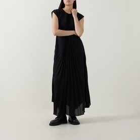 Model wearing HIGH black pleated maxi dress with cap sleeves, styled with black leather loafers