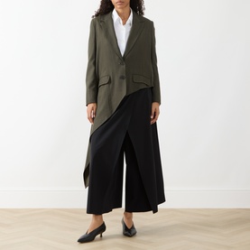 Model wearing HIGH khaki wool-lyocell blazer jacket, styled with black wide-leg trousers and white shirt