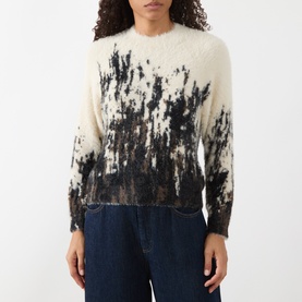 Model wearing HIGH multi abstract brushstroke knit sweater with cream and black pattern, styled with dark denim jeans.