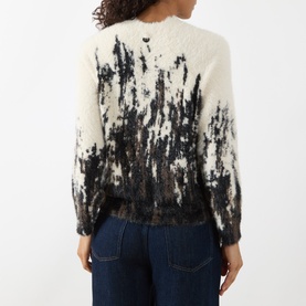 Model wearing HIGH multi abstract print fluffy knit sweater, back view, styled with dark denim jeans