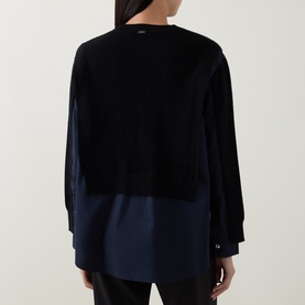 Model wearing HIGH black virgin wool shirt with contrast navy satin hem panel, long sleeves, rear view