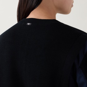 Model wearing HIGH black virgin wool knit top, close-up of back neckline with logo tab detail