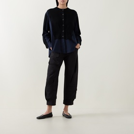 Model wearing HIGH black cropped cargo trousers with elasticated ankles, styled with a navy collarband shirt and black flat shoes.