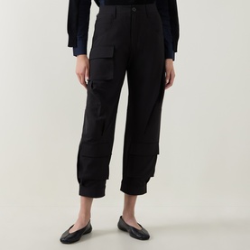 Model wearing HIGH black cargo-style cropped trousers with utility pockets, styled with black ballet flats and navy top.