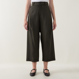 Model wearing HIGH khaki wide-leg cropped trousers in wool-lyocell blend, styled with black Mary Jane flats.