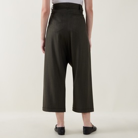 Model wearing HIGH khaki wide-leg cropped trousers, back view, styled with black flat shoes