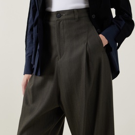 Model wearing HIGH khaki wide-leg tailored trousers in wool-lyocell blend, styled with a navy shirt and dark jacket