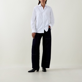 Model wearing HIGH navy wide-leg cotton trousers with contrast stitching, styled with a white shirt and black heeled ankle boots