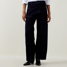 Model wearing HIGH navy wide-leg cotton cargo trousers with contrast stitching, styled with a white shirt and black leather shoes.