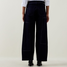 Model wearing HIGH navy wide-leg trousers with contrast stitching and patch pockets, styled with a white shirt and black shoes