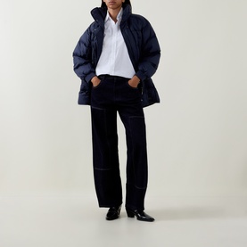 Model wearing HIGH navy cotton wide-leg trousers, styled with a navy puffer jacket, white shirt and black leather ankle boots.