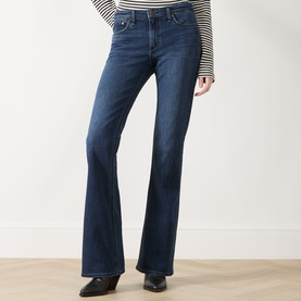 Model wearing Rag & Bone bootcut jeans in lulu, dark blue wash, with a striped top and black ankle boots.