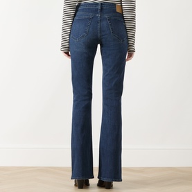 Model wearing Rag & Bone bootcut jeans in lulu denim, rear view, styled with a striped long-sleeve top and black heels.