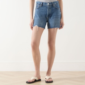 Model wearing Rag & Bone flora denim shorts with raw frayed hem, styled with white toe-post sandals.
