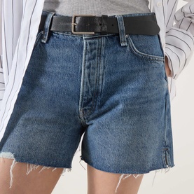 Model wearing Rag & Bone flora denim shorts with raw-hem frayed edges and black leather belt, styled with a striped shirt