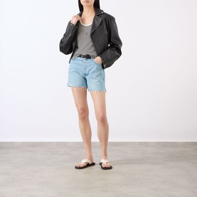 Model wearing Rag & Bone denim shorts in narrows, light blue wash with frayed hem, styled with black leather jacket and grey top.