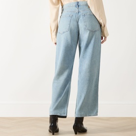 Model wearing Rag & Bone straight-leg jeans in light wash denim, high-rise waist, wide leg, styled with black ankle boots and cream top.