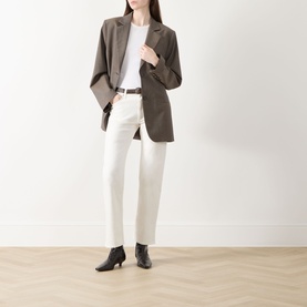 Model wearing Rag & Bone Miramar Harlow Ankle Straight-Leg Jeans in white, styled with a brown blazer, white top, and black ankle boots.