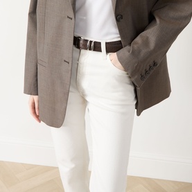 Model wearing Rag & Bone Miramar Harlow Ankle Straight-Leg Jeans in white, styled with a brown blazer and dark leather belt.