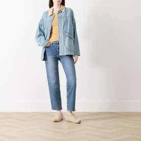 Model wearing Rag & Bone Straight Jeans in accord blue, styled with a light denim jacket, yellow top and beige trainers.