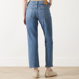 Model wearing Rag & Bone Straight Jeans in accord blue denim, rear view, styled with cream trainers.