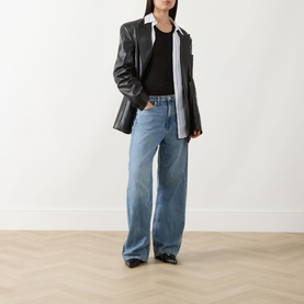 Model wearing Rag & Bone Wide Leg Jeans in lyon blue, styled with a black tee and oversized dark leather blazer.
