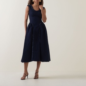 Model wearing Self-Portrait Boucl&eacute; Flared Dress in navy, featuring scoop neckline, sleeveless midi length with frayed trims and pleated skirt, styled
