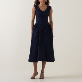 Model wearing Self-Portrait Boucl&eacute; Flared Dress in navy, featuring scoop neckline, frayed trims, and pleated midi skirt, styled with brown heeled