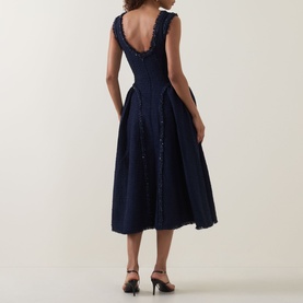 Model wearing Self-Portrait Boucl&eacute; Flared Dress in navy, showing back view with scoop neckline, frayed trims, glittering embellishment and pleated