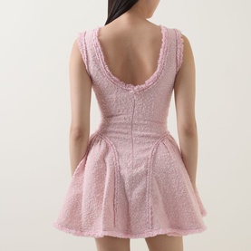 Model wearing Self-Portrait pink textured mini dress, rear view showing low scoop back, sleeveless design and flared skirt