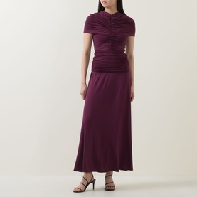 Model wearing Self-Portrait burgundy ruched maxi dress with short sleeves and flared skirt, styled with black heeled sandals.