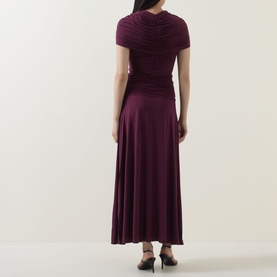Model wearing Self-Portrait burgundy maxi dress with ruched bodice, short sleeves and flared skirt, back view.