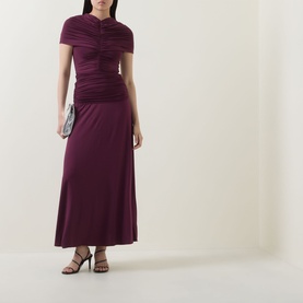 Model wearing Self-Portrait burgundy ruched short-sleeve maxi dress, styled with silver clutch bag and black strappy heels.