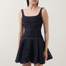 Model wearing Self-Portrait blue denim mini dress with square neckline, fitted bodice, flared skirt and floral broderie anglaise hem detail.