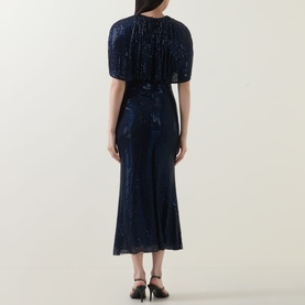 Model wearing Self-Portrait navy blue sequin midi dress, back view, short puff sleeves, with black heeled mules.