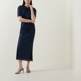 Model wearing Self-Portrait navy blue sequin midi dress with short sleeves, ruched waist, and side slit, styled with black heeled sandals