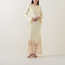 Model wearing Self-Portrait yellow maxi dress with flared sleeves and lace hem detail, styled with gold strappy sandals