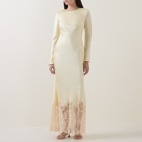 Model wearing Self-Portrait yellow maxi dress with long sleeves, satin finish and floral lace hem detail.