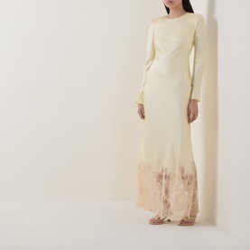Model wearing Self-Portrait yellow maxi dress with long sleeves, lace hem detail, styled with nude strappy sandals.