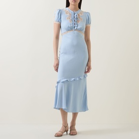 Model wearing Self-Portrait blue midi dress with lace trim bodice, puff sleeves, and ruffle hem, styled with nude heeled sandals.