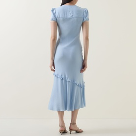 Model wearing Self-Portrait blue midi dress, back view, short sleeves, ruffle hem detail, styled with tan strappy sandals