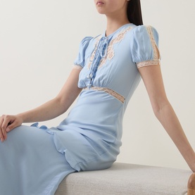 Model wearing Self-Portrait blue viscose midi dress with lace trim detail, puff sleeves, and cut-out waist panel