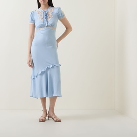 Model wearing Self-Portrait blue viscose midi dress with floral embroidery, puff sleeves, lace-up detail, and ruffle hem, styled with strappy heeled