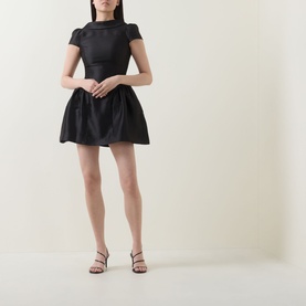 Model wearing Self-Portrait black mini dress with cap sleeves, mesh neckline, and full skirt, styled with strappy heeled sandals.