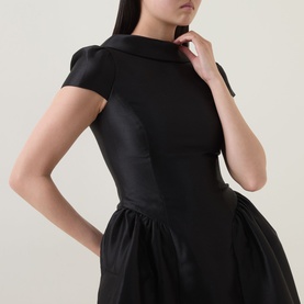 Model wearing Self-Portrait black structured dress with fitted bodice, cap sleeves, high neck, and voluminous full skirt in satin-finish fabric.