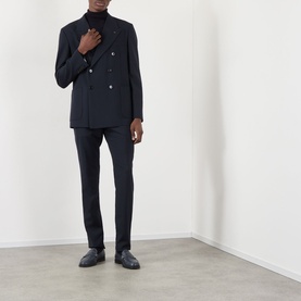 Model wearing Valentino storm blue wool double-breasted blazer with silver buttons, styled with matching trousers and black loafers.